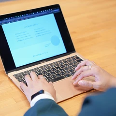 ノートパソコンで作業する人の手元
